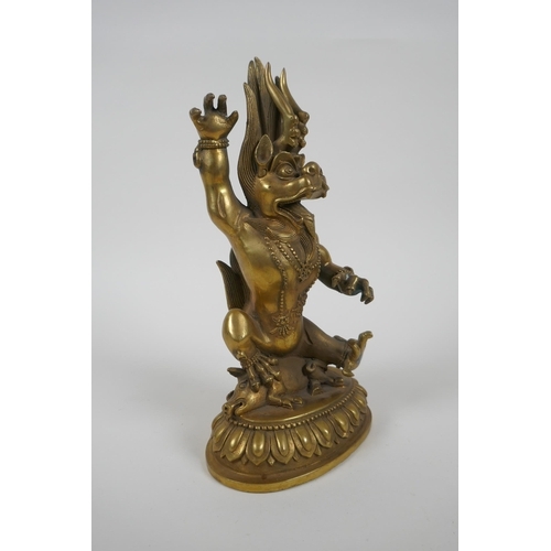 144 - A Tibetan bronze of a wrathful beast seated on a pig, double vajra mark to base, 22cm high