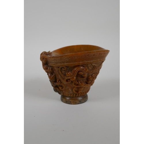 163 - A Chinese faux horn libation cup decorated with kylin and auspicious symbols, seal mark to base, 10c... 