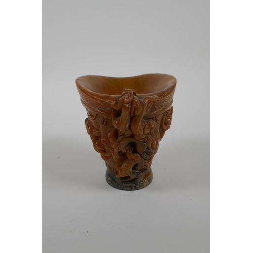 163 - A Chinese faux horn libation cup decorated with kylin and auspicious symbols, seal mark to base, 10c... 