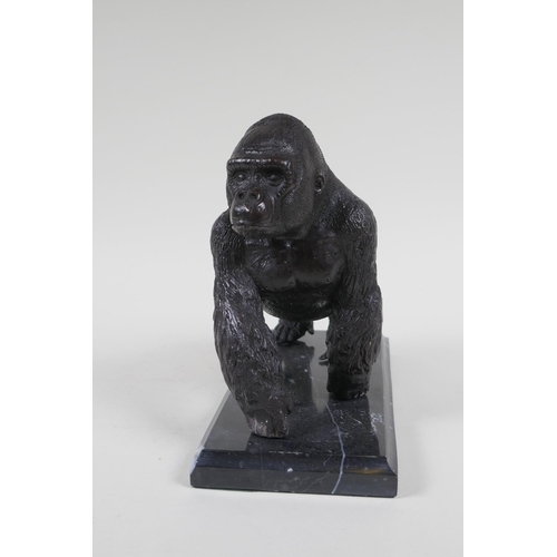 198 - A cast bronzed metal gorilla, mounted on a marble base, 18cm high