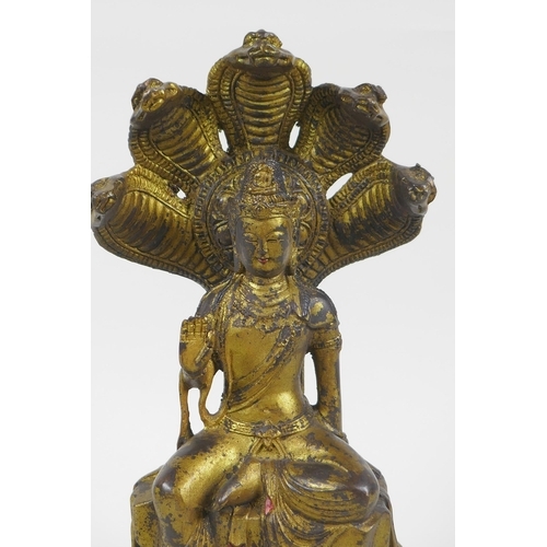 201 - A Sino Tibetan gilt bronzed metal Buddha seated on a cobra throne, impressed Yongle 6 character mark... 