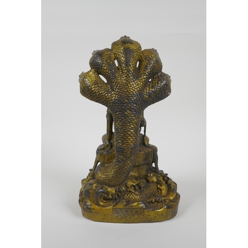 201 - A Sino Tibetan gilt bronzed metal Buddha seated on a cobra throne, impressed Yongle 6 character mark... 