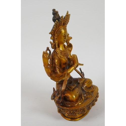 207 - A Tibetan gilt bronze figure of a female deity, double vajra mark to base, 21cm high