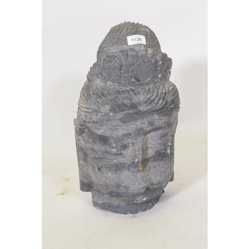 1126 - A carved schist stone Buddha's head, 42cm high