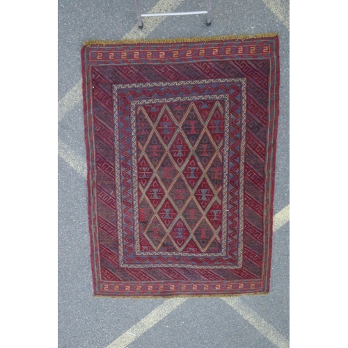 1098 - A Persian red ground wool rug with geometric bokhara style design, 126 x 180cm