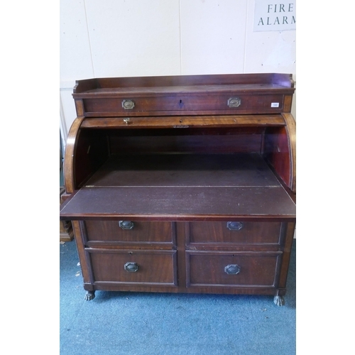 1085 - A C19th mahogany cylinder bureau with fold down work surface over four drawers, raised on brass paw ... 