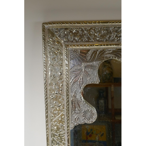 1065 - A Moorish white metal mirror with repousse floral decoration, 61 x 77cm