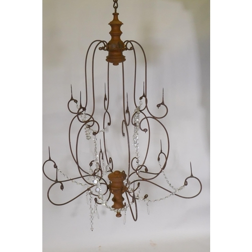 1040 - A wrought iron and pine six branch chandelier, with twelve candle prickets and glass lustre swags, 9... 