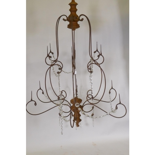 1040 - A wrought iron and pine six branch chandelier, with twelve candle prickets and glass lustre swags, 9... 