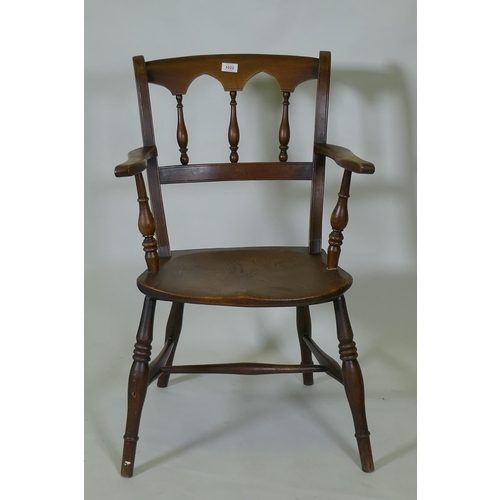 1022 - A C19th elm Oxford elbow chair with arched spindle back