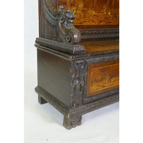 1021 - An early C19th Continental marquetry inlaid settle, the seat back and front panel decorated with hun... 