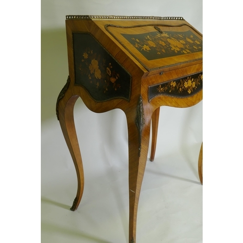 1015 - A French marquetry inlaid kingwood bureau-de-dame, with brass mounts, the fall front folding down to... 