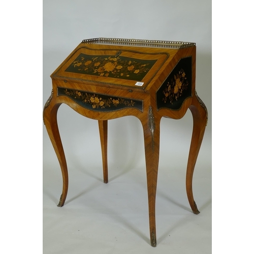 1015 - A French marquetry inlaid kingwood bureau-de-dame, with brass mounts, the fall front folding down to... 