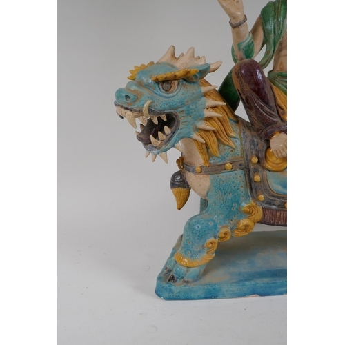 328 - A Chinese Sancai glazed pottery figure of an immortal riding a kylin, 47cm high