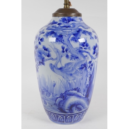 334 - A C19th Japanese blue and white porcelain vase decorated with a crane in a landscape, converted to a... 