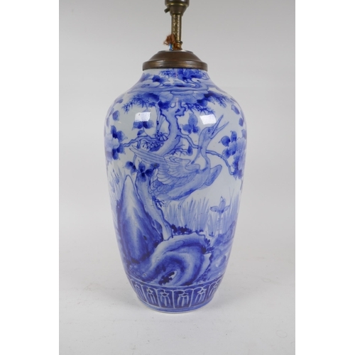 334 - A C19th Japanese blue and white porcelain vase decorated with a crane in a landscape, converted to a... 