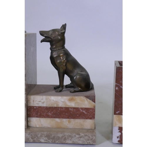 610 - An Art Deco French rouge marble mantel clock garniture, with bronzed metal figures of Alsatian dogs,... 