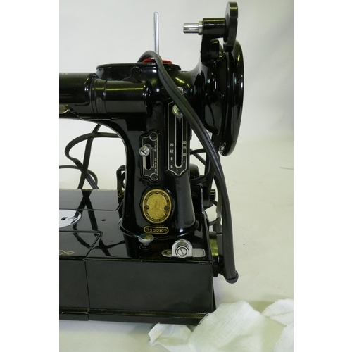 140 - A vintage Singer 222K electric sewing machine, appears unused, and a sewing workbox