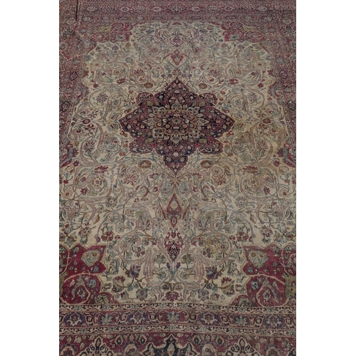 1071 - An antique Persian carpet, medallion design on a red field, pile worn/20cm tear, 270 x 362cm