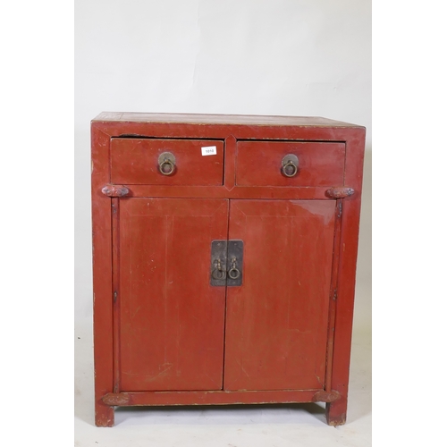 1010 - A Chinese red lacquered wood cabinet with two drawers over two doors, 74 x 50cm, 87cm high