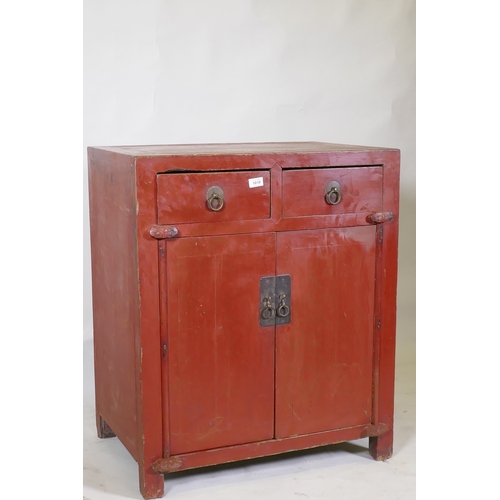 1010 - A Chinese red lacquered wood cabinet with two drawers over two doors, 74 x 50cm, 87cm high