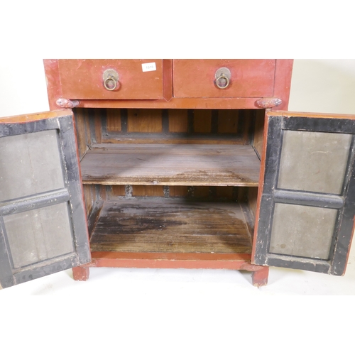 1010 - A Chinese red lacquered wood cabinet with two drawers over two doors, 74 x 50cm, 87cm high