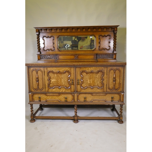 1039 - An early C20th oak Jacobean style mirror back sideboard, with two cupboards opening to reveal shelve... 