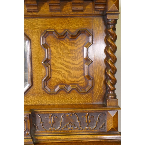 1039 - An early C20th oak Jacobean style mirror back sideboard, with two cupboards opening to reveal shelve... 