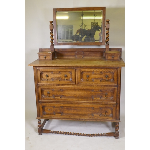 1041 - An early C20th oak Jacobean style dressing table, with swing mirror supported by barley twist column... 