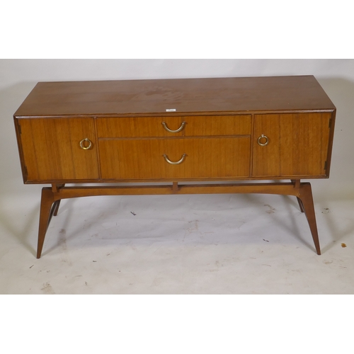 1042 - A mid century teak dressing table/low side cabinet, with two cupboards flanking two drawers, raised ... 