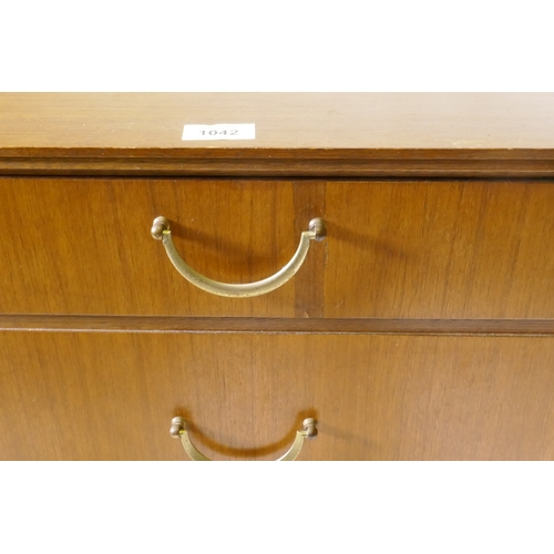 1042 - A mid century teak dressing table/low side cabinet, with two cupboards flanking two drawers, raised ... 