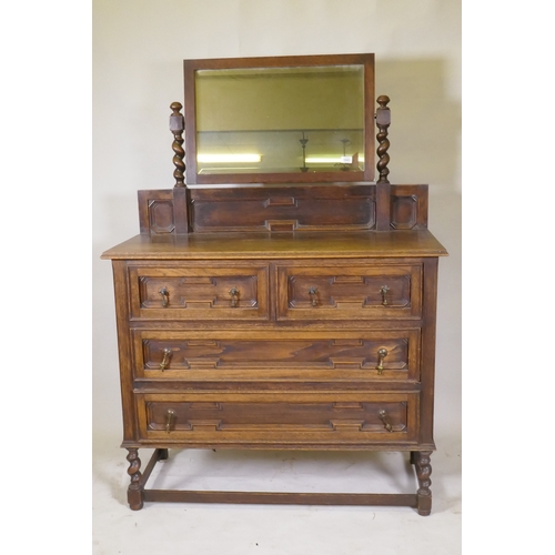 1043 - An early C20th oak Jacobean style dressing table, the swing mirror on barley twist columns, two over... 