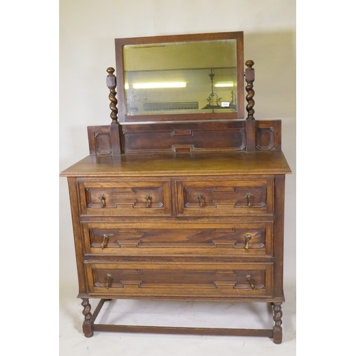 1043 - An early C20th oak Jacobean style dressing table, the swing mirror on barley twist columns, two over... 