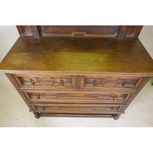 1043 - An early C20th oak Jacobean style dressing table, the swing mirror on barley twist columns, two over... 