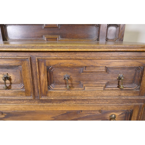 1043 - An early C20th oak Jacobean style dressing table, the swing mirror on barley twist columns, two over... 