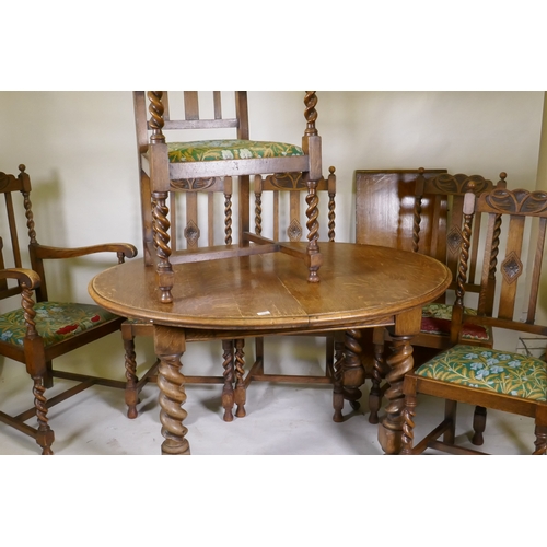 1045 - An early C20th oak wind out dining table, with extra leaf, raised on handed barley twist supports, a... 