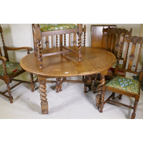 1045 - An early C20th oak wind out dining table, with extra leaf, raised on handed barley twist supports, a... 