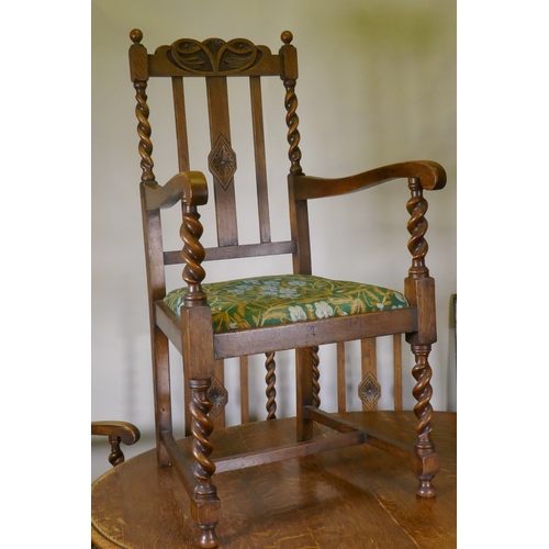 1045 - An early C20th oak wind out dining table, with extra leaf, raised on handed barley twist supports, a... 