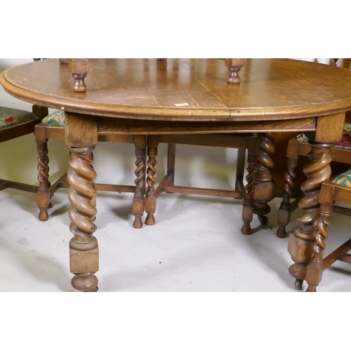 1045 - An early C20th oak wind out dining table, with extra leaf, raised on handed barley twist supports, a... 