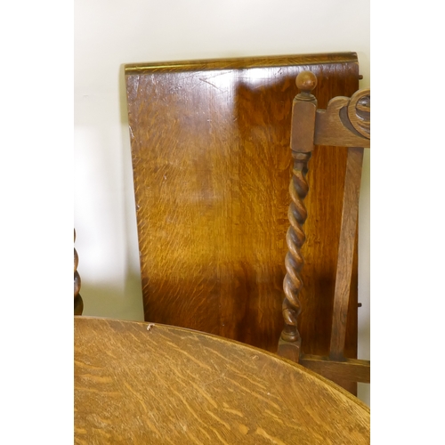 1045 - An early C20th oak wind out dining table, with extra leaf, raised on handed barley twist supports, a... 