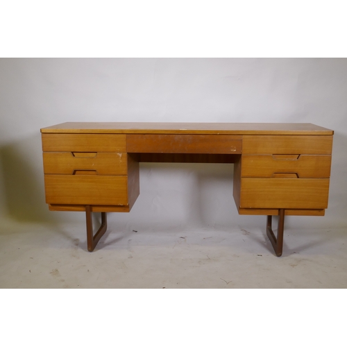 1049 - A mid century teak dressing table/side cabinet with seven drawers, raised on end supports, labelled ... 