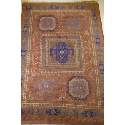 1054 - An antique Bergama carpet, with geometric designs on a terracotta coloured field and soft sheen to t... 