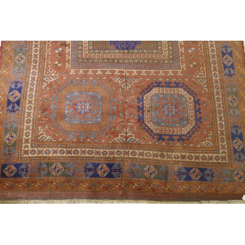 1054 - An antique Bergama carpet, with geometric designs on a terracotta coloured field and soft sheen to t... 