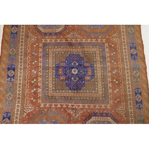 1054 - An antique Bergama carpet, with geometric designs on a terracotta coloured field and soft sheen to t... 