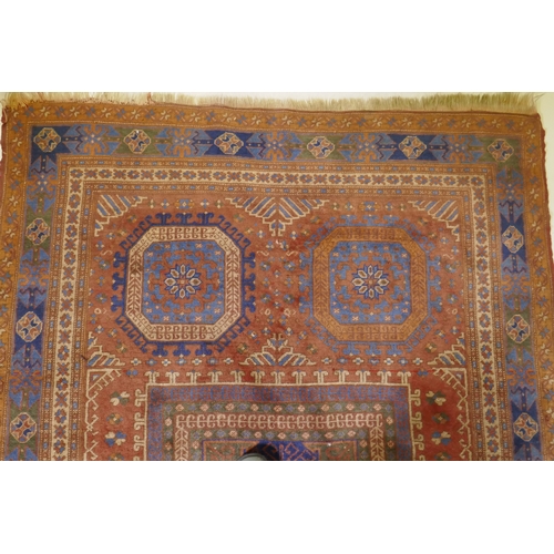 1054 - An antique Bergama carpet, with geometric designs on a terracotta coloured field and soft sheen to t... 