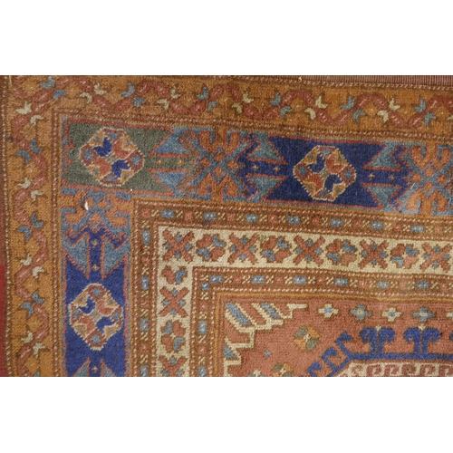 1054 - An antique Bergama carpet, with geometric designs on a terracotta coloured field and soft sheen to t... 