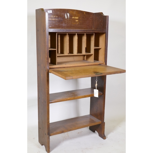 1058 - An Arts and Crafts oak bureau, with fall front and fitted interior over two open shelves, 61 x 22 x ... 