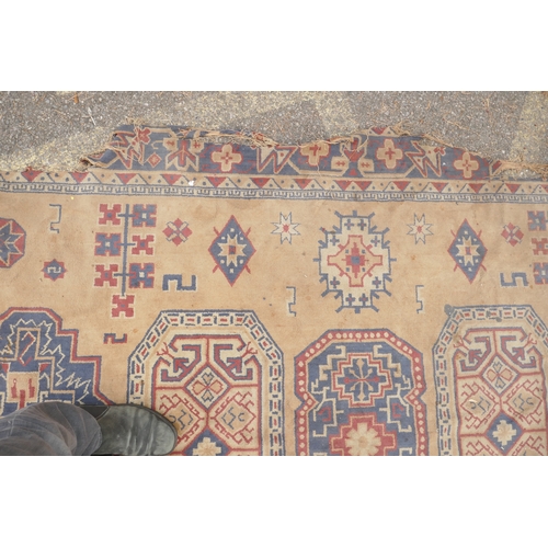 1059 - A wool carpet with oriental style design, frayed and worn, 270 x 180cm