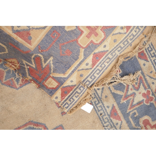 1059 - A wool carpet with oriental style design, frayed and worn, 270 x 180cm