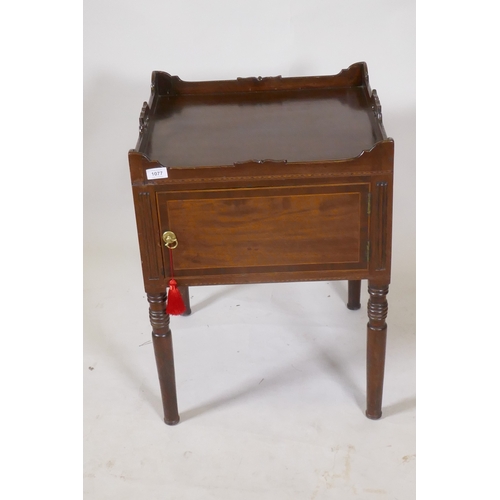 1077 - A Georgian mahogany pot cupboard, with carved galleried top, single door, raised on turned supports,... 